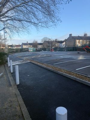 Completed surface car park in Stratford with freshly painted parking bays, line markings, and perimeter fencing