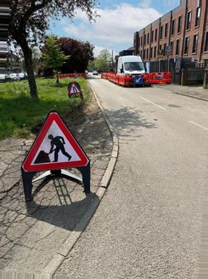 Orange safety barriers and Footway Closed Ahead signage protecting an LV cable trench on Aycliffe Road, Borehamwood, with adjacent property frontages