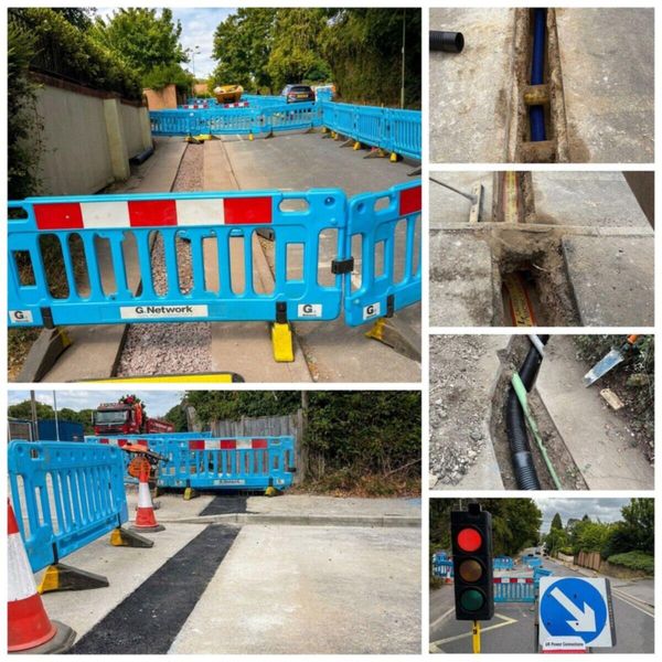 LV electricity network installation on Anstey Lane, Alton, showing two way portable traffic signals, joint bay duct work, and asphalt reinstatement for the Meadow Vale residential development
