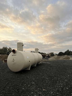 Industrial outlet tank installed on gravel surface at the Copart Dunfermline site with aggregate stockpiles and plant in the background