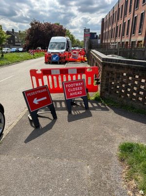 Red Footway Closed Ahead and Pedestrians diversion signage and barriers managing pedestrian flow around live highway LV works in Borehamwood