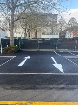 Freshly surfaced car park with white directional arrows and parking bay markings at UEL Stratford