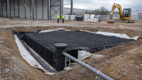 Surface water attenuation crates and drainage pipe within a protected excavation at a UK warehouse construction site